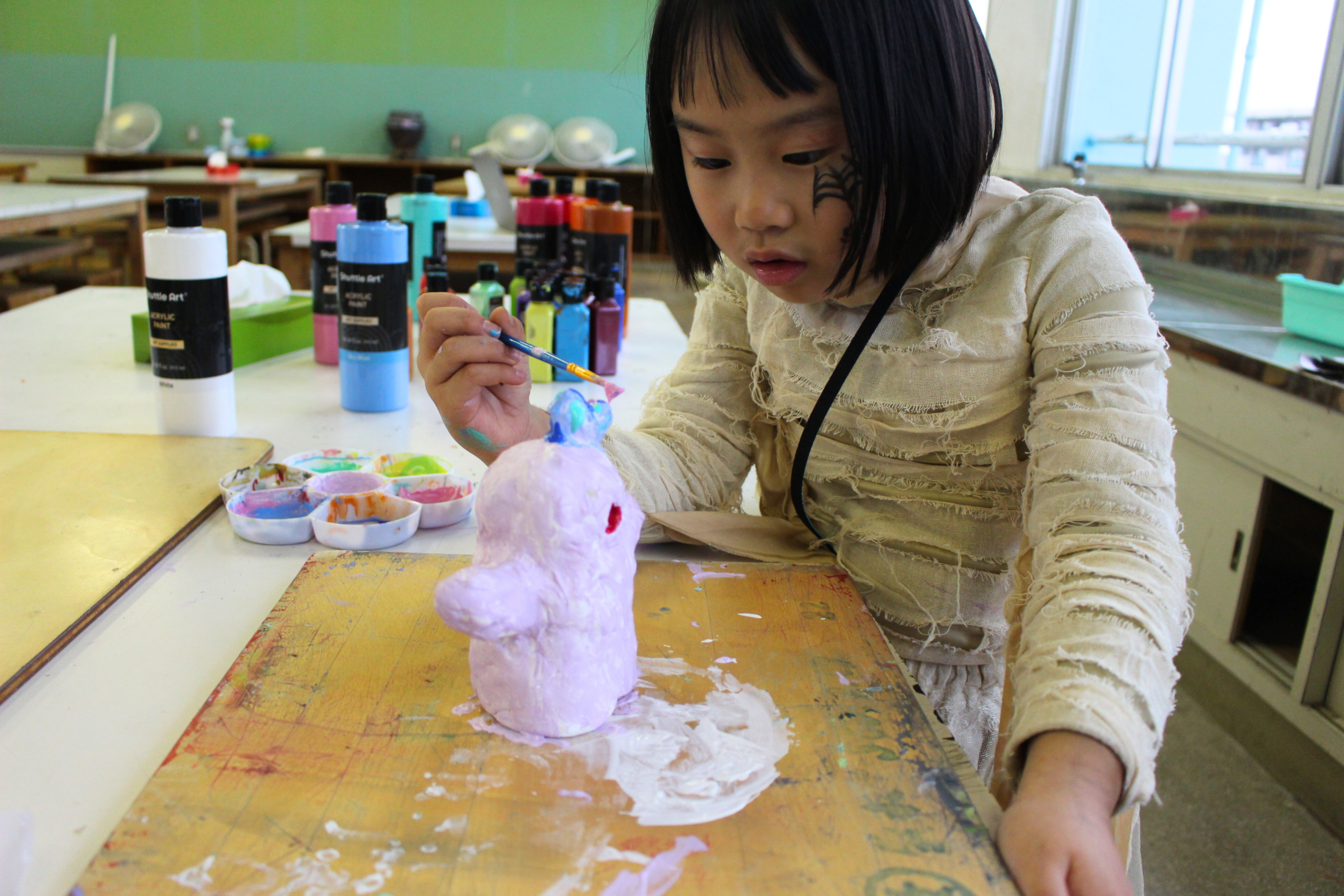 ACES Girl in Afterschool Pottery class, painting her own pottery